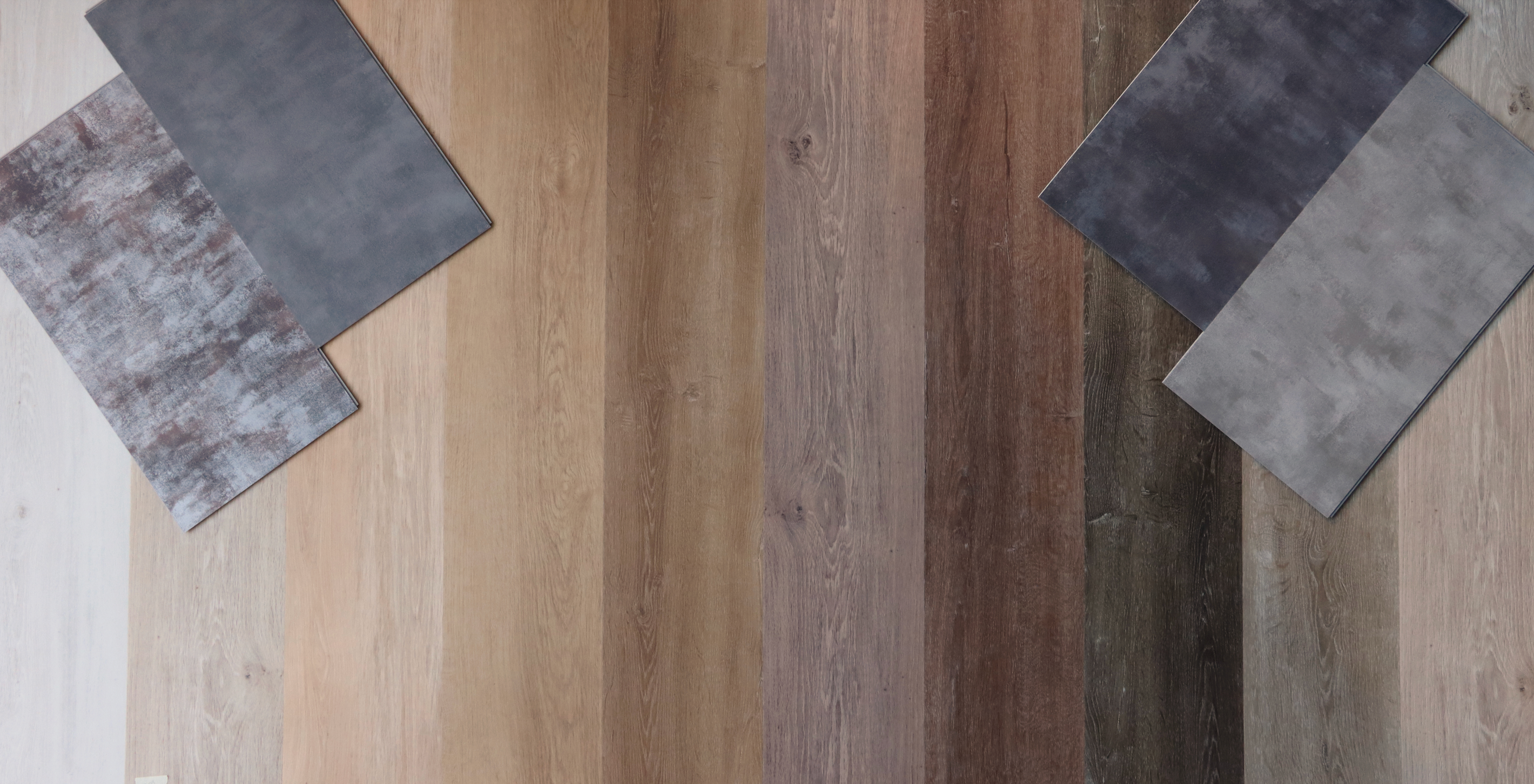 Ein Grossteil der Auswahl an Vinylböden von Vundament. Die Holz- und Stein-Optik-Dielen sind farblich sortiert und von Oben her zu sehen.